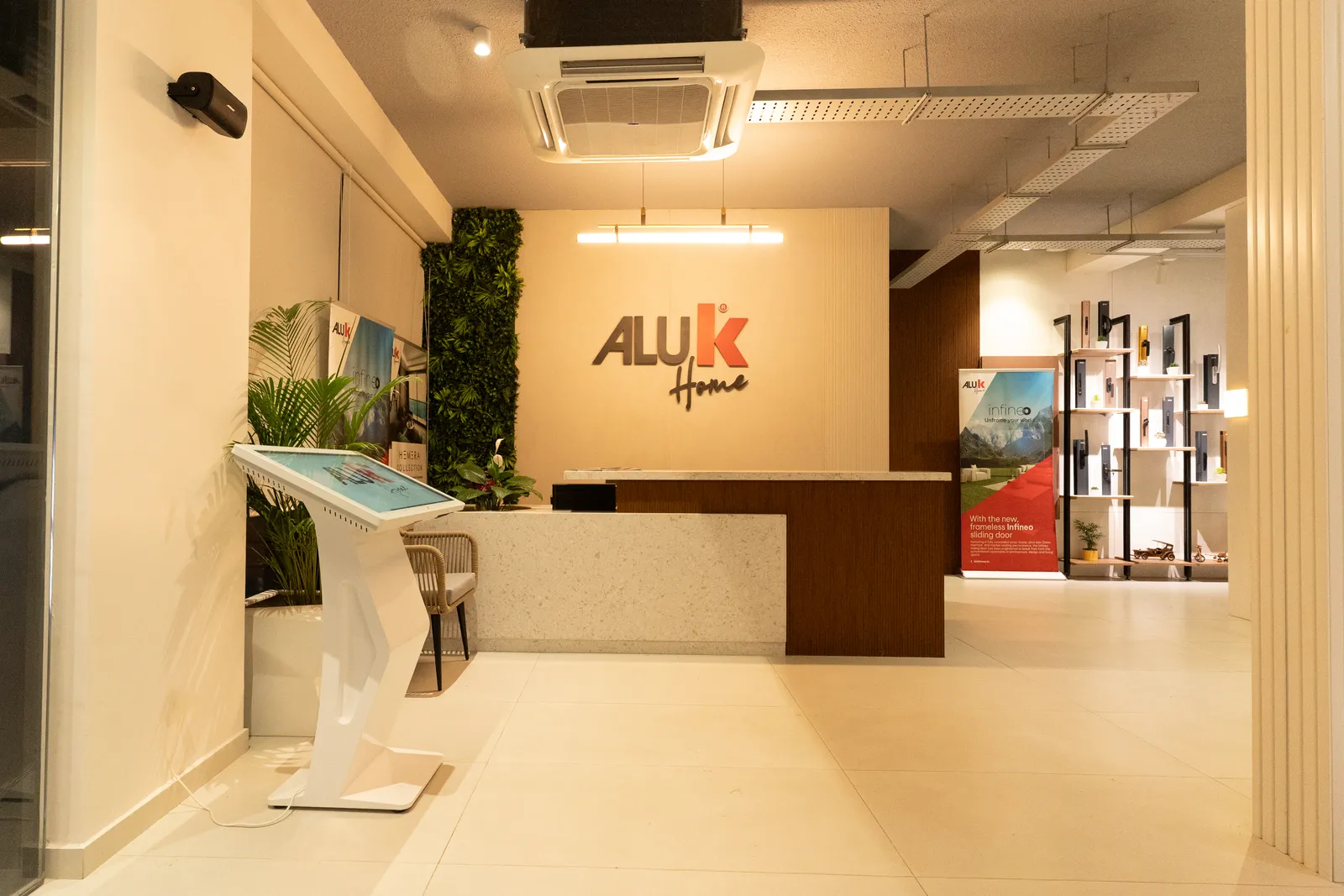 Showroom reception with Aluk logo and green wall — Aluk Experience Center